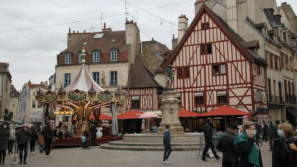 Rue commerçante du centre-ville de Dijon avec façades anciennes et terrasses de café
